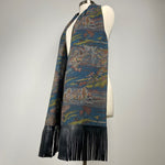 A dark blue kimono silk scarf with black leather fringe. Silk has scenery of people on a journey