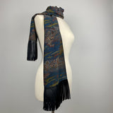 A dark blue kimono silk scarf with black leather fringe. Silk has scenery of people on a journey